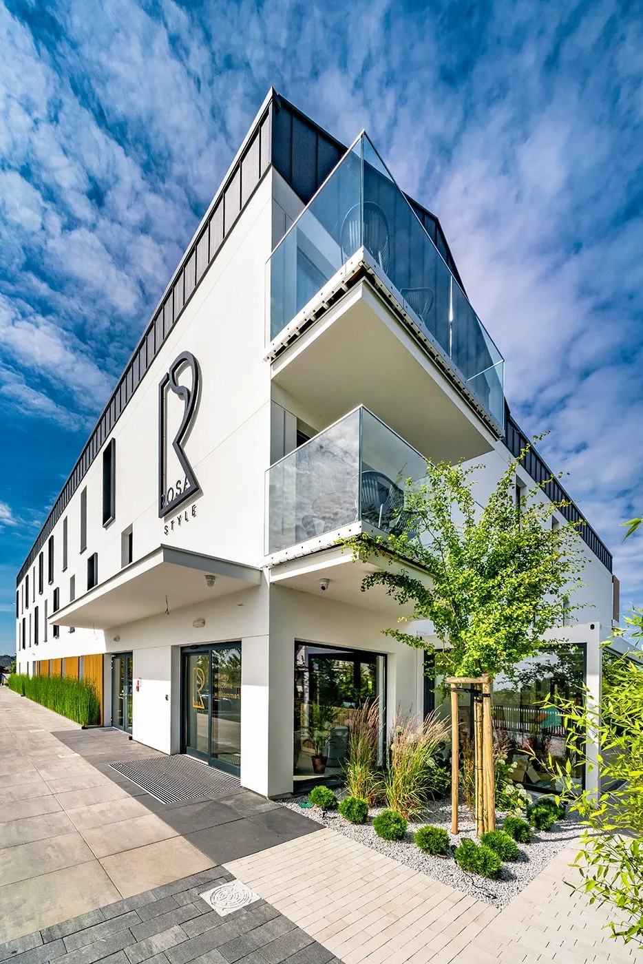 Wejście i balkony apartamentów wśród zieleni, Apartamenty Rosa Style