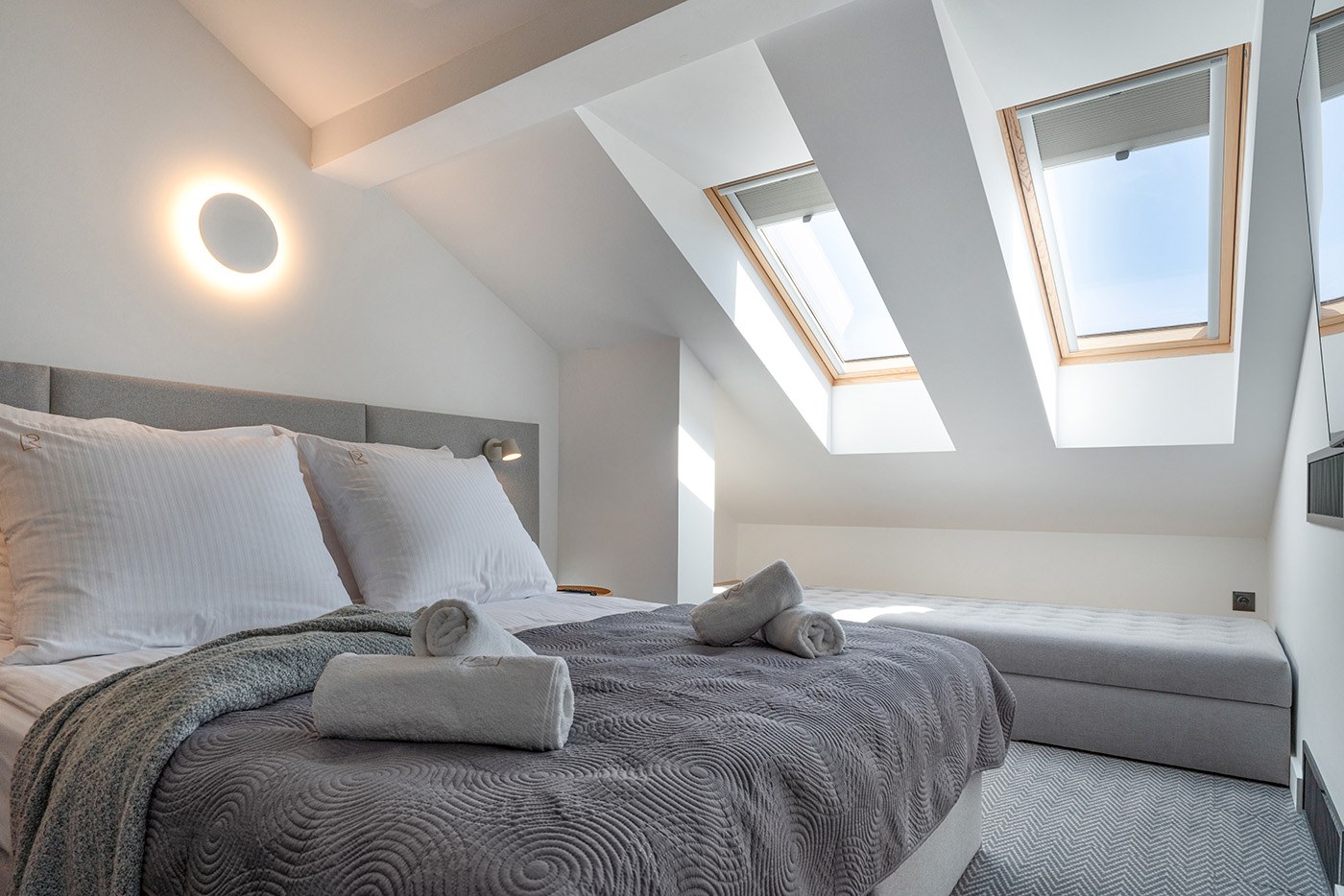 Salon z sofą i drewnianą podłogą w jodełkę, Apartamenty Rosa Style
