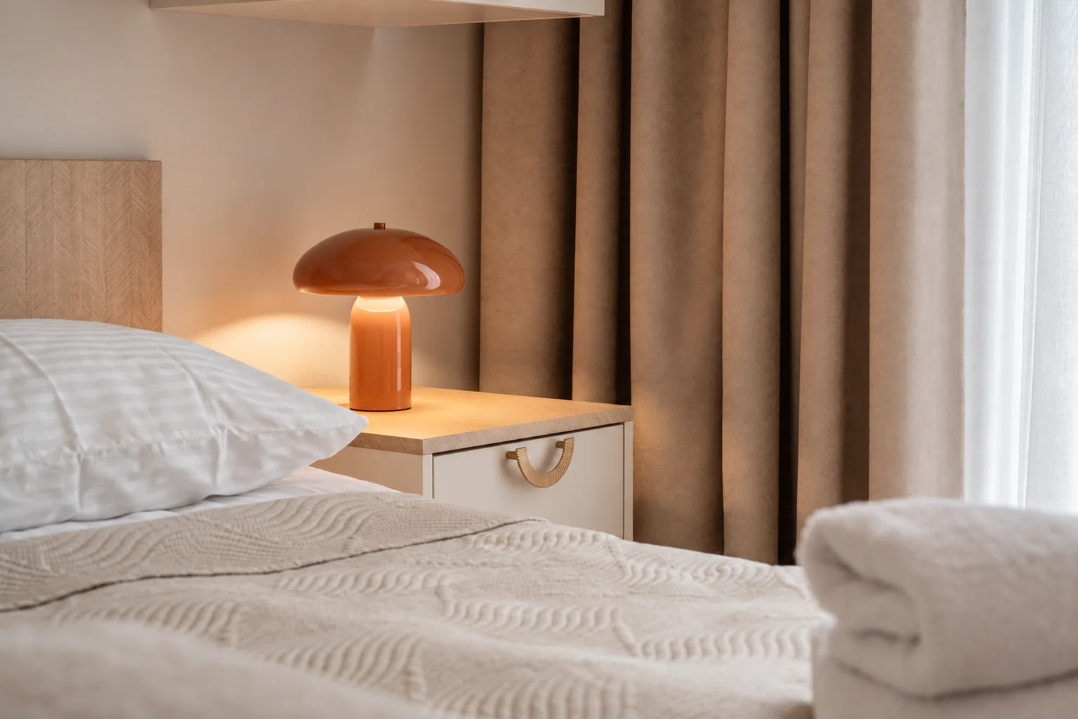 Lampa i łóżko w sypialni apartamentu Klifowa 22 w Rewalu