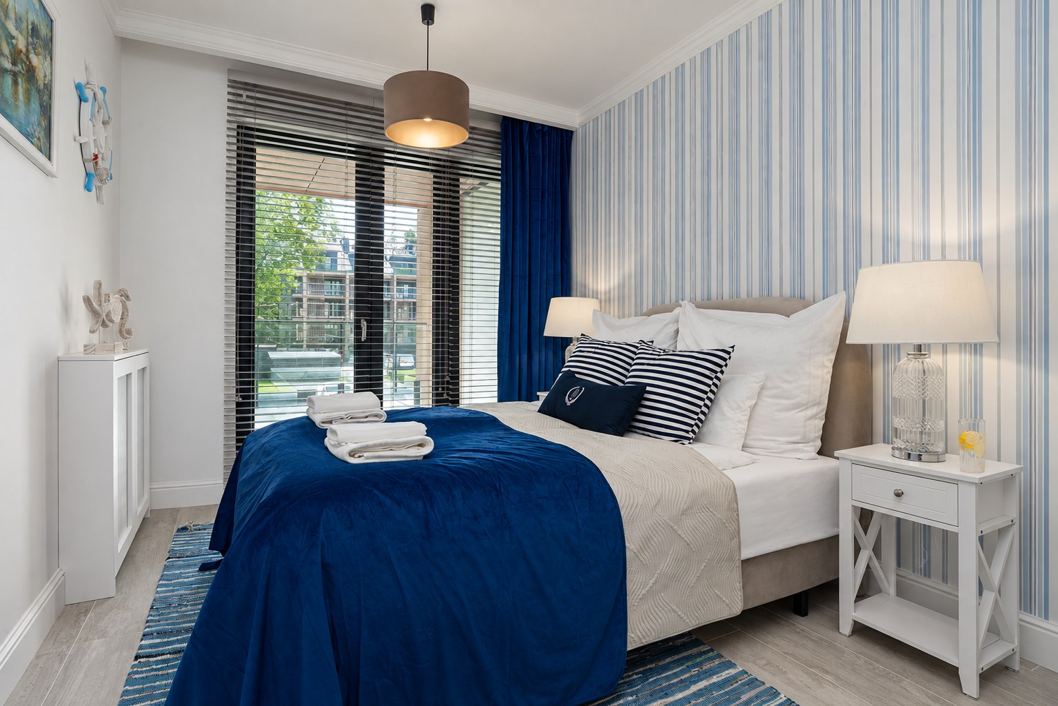 Sypialnia z błękitną ścianą i białymi meblami, Apartament Sea & Forest, Międzyzdroje