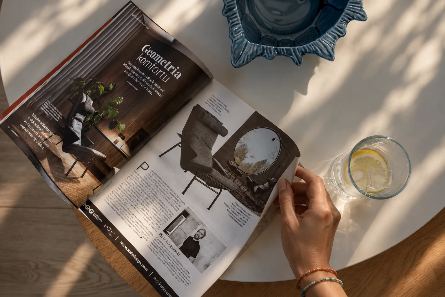 Dłoń przewracająca magazyn obok szklanki z cytryną w domku SOL w Trzęsaczu