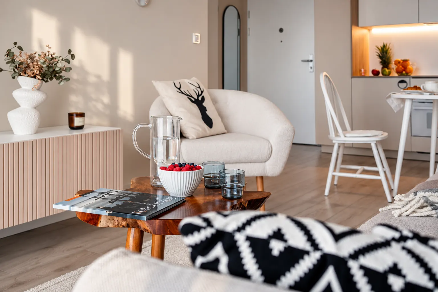 Fotel i drewniana komoda w smudze światła, Apartament Arena, Kołobrzeg