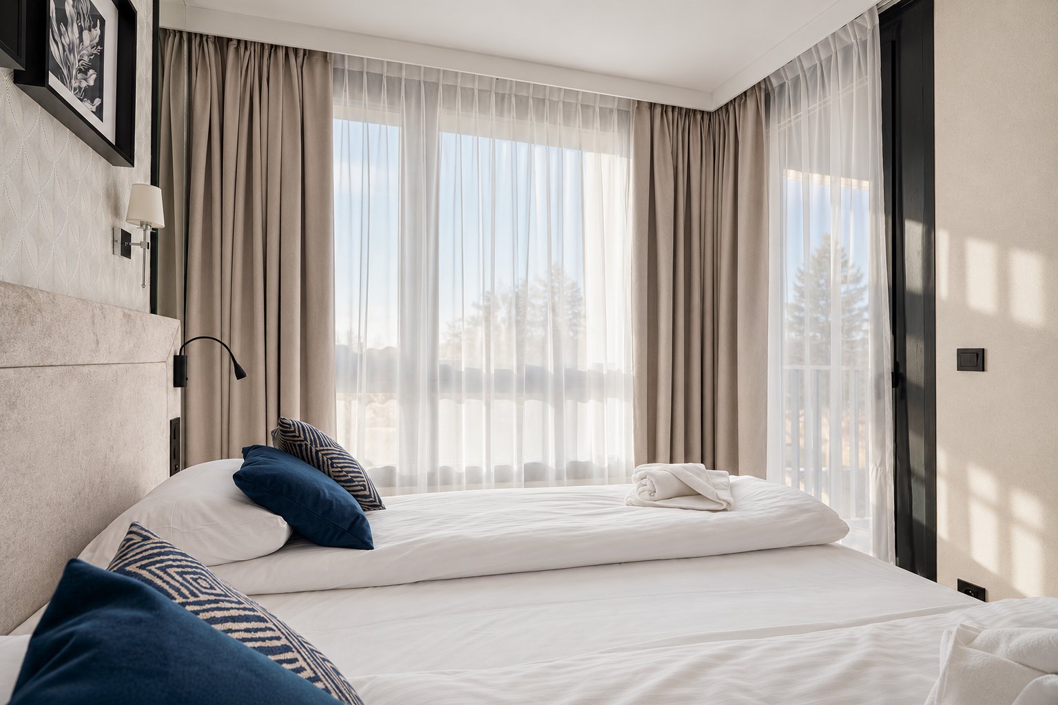 Dwa złączone łóżka przy dużym oknie z miękkim światłem, Apartament w Central Park Mielno