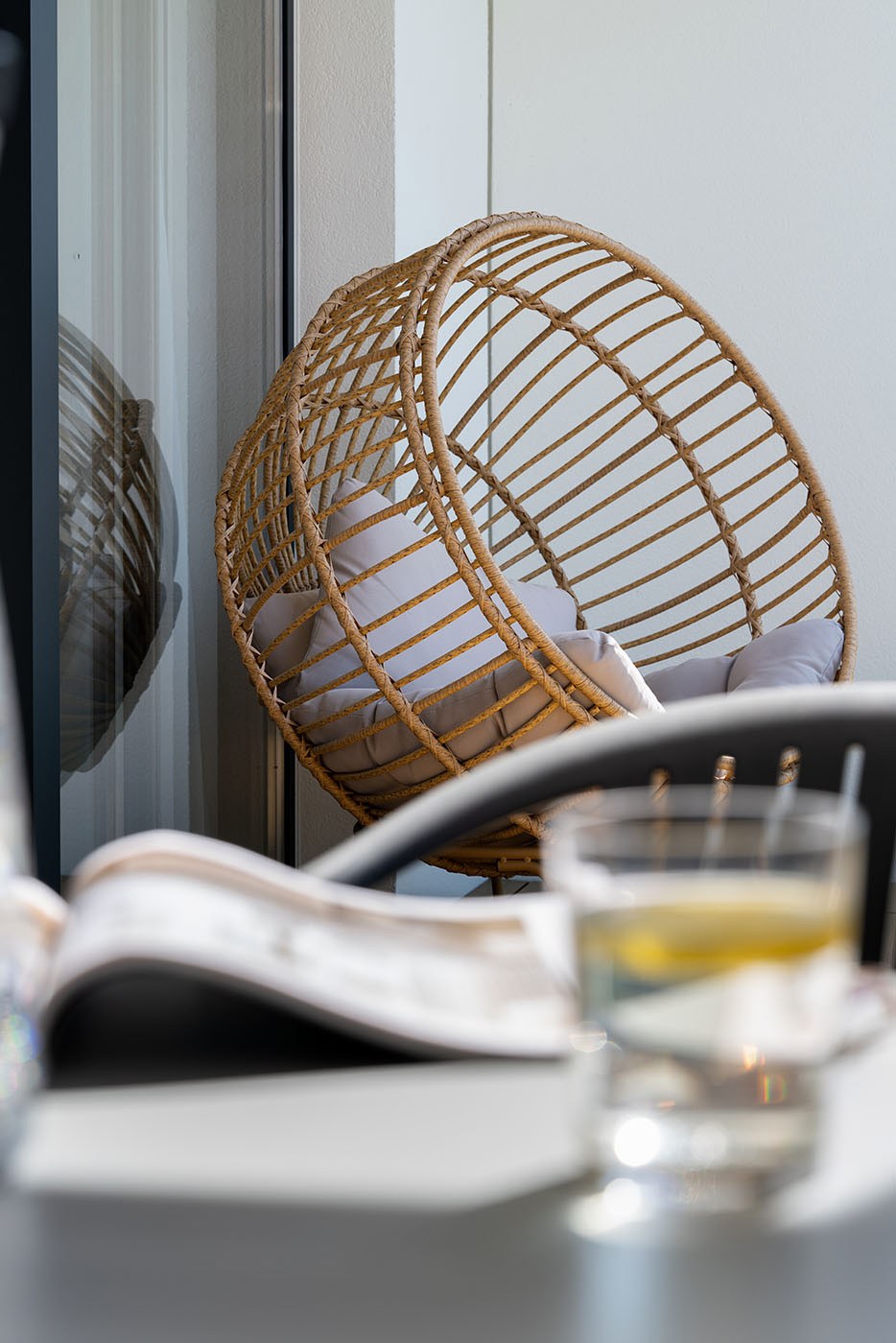Fotel wiszący przy oknie i miękkim świetle, Apartamenty Rosa Style