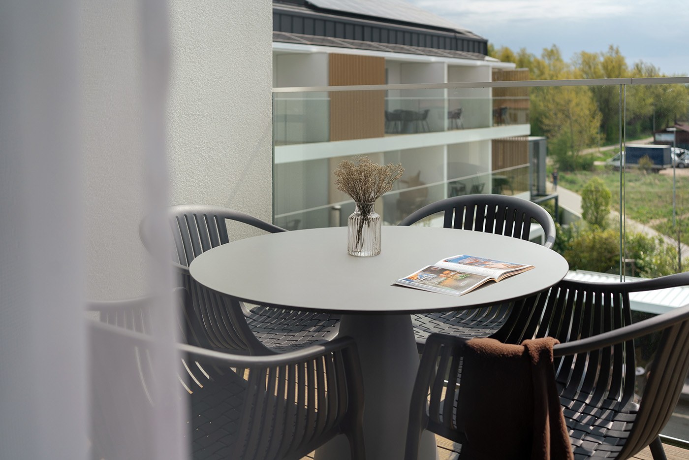 Nakryty stolik na balkonie z widokiem na zieleń, Apartamenty Rosa Style