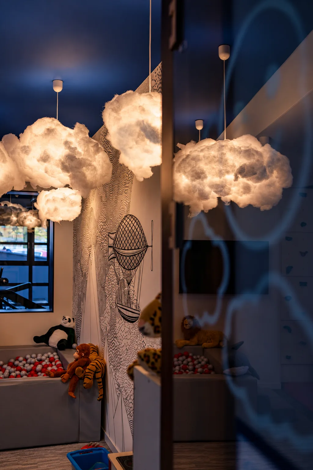 Lampy w kształcie chmur i mural ze sterowcem w sali zabaw WhiteBlue w Kołobrzegu