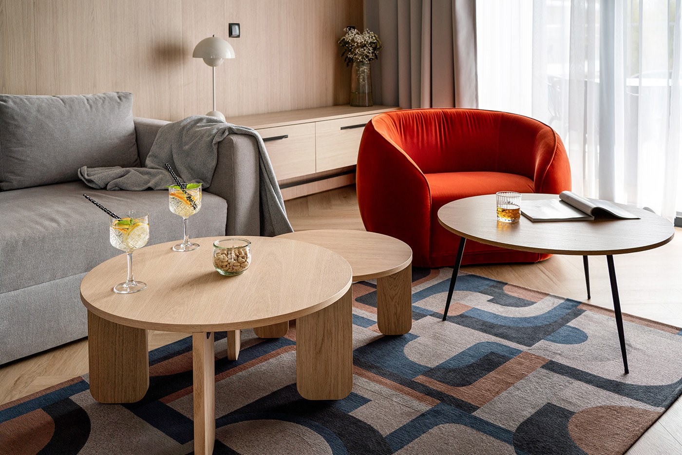 Salon z czerwonym fotelem i niskim stolikiem, Apartamenty Rosa Style