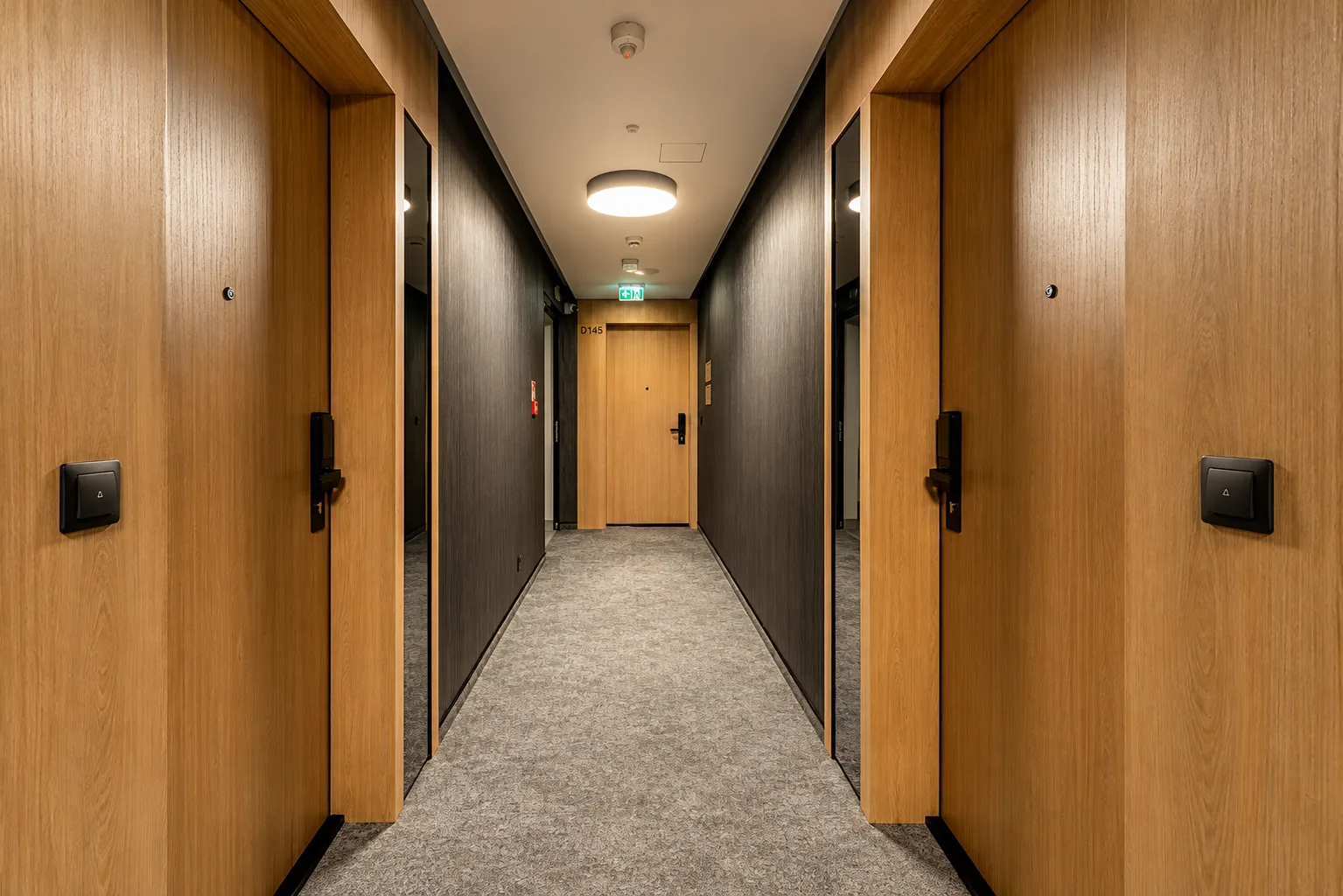 Korytarz z drewnianymi drzwiami apartamentów w budynku Sea & Forest w Międzyzdrojach
