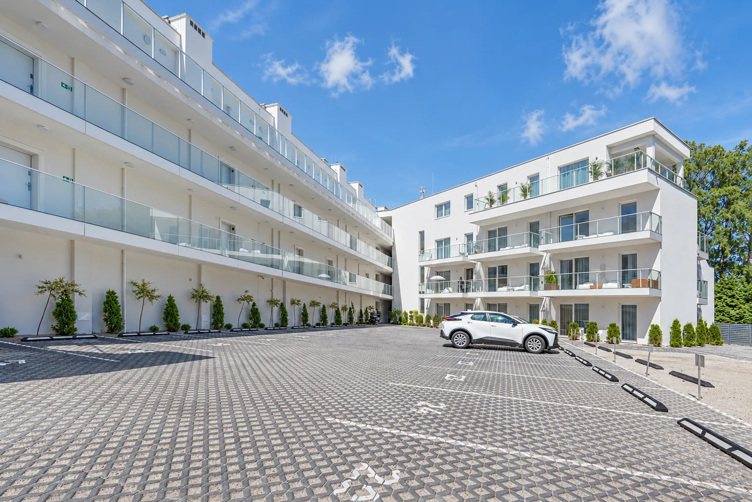 Narożnik budynku Apartamentów Klifowa 22 z tarasami i przeszklonymi balustradami