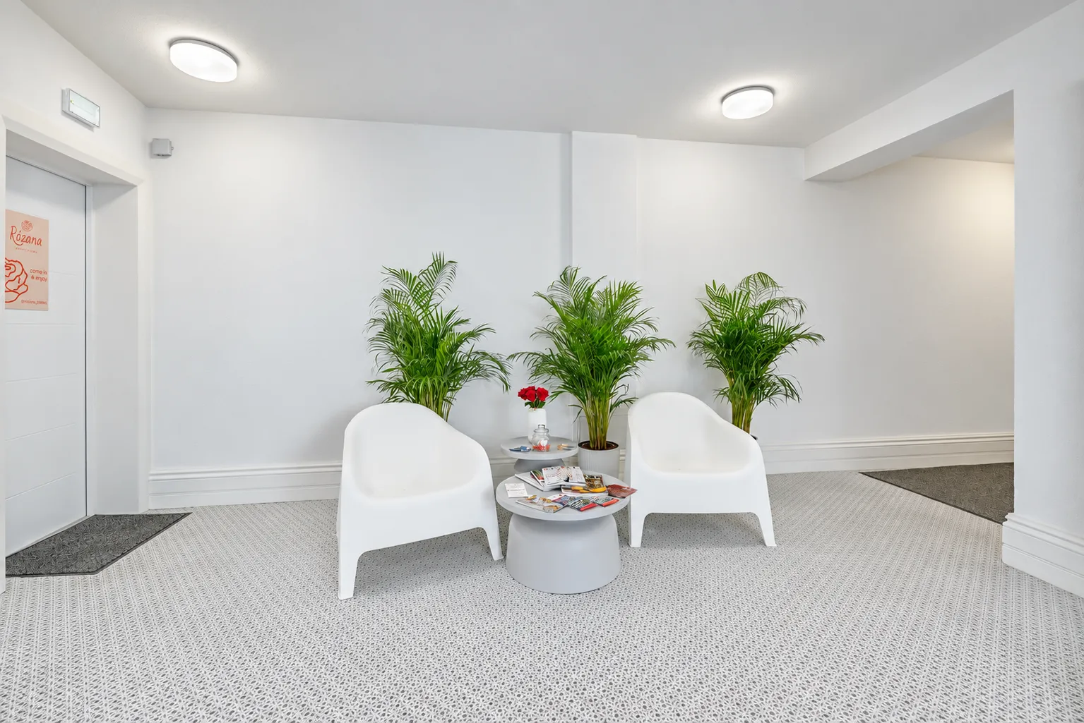 Strefa oczekiwania z białymi fotelami w holu Apartamentów Klifowa 22