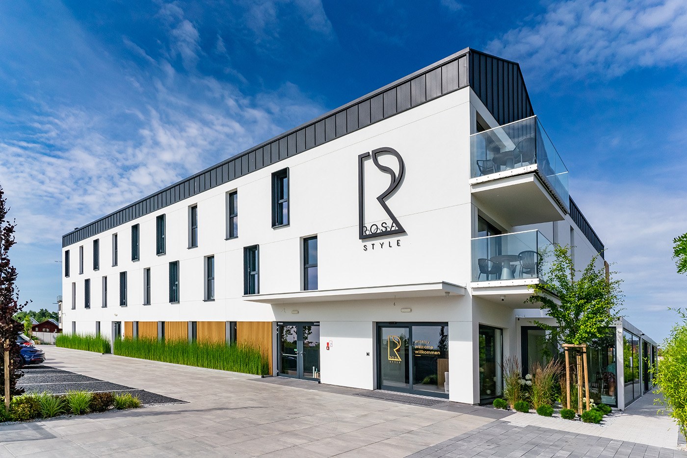 Długa elewacja apartamentów w słoneczny dzień, Apartamenty Rosa Style