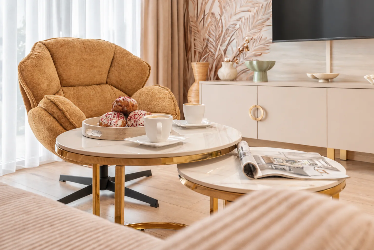 Musztardowy fotel i marmurowe stoliki w apartamencie Klifowa 22 w Rewalu