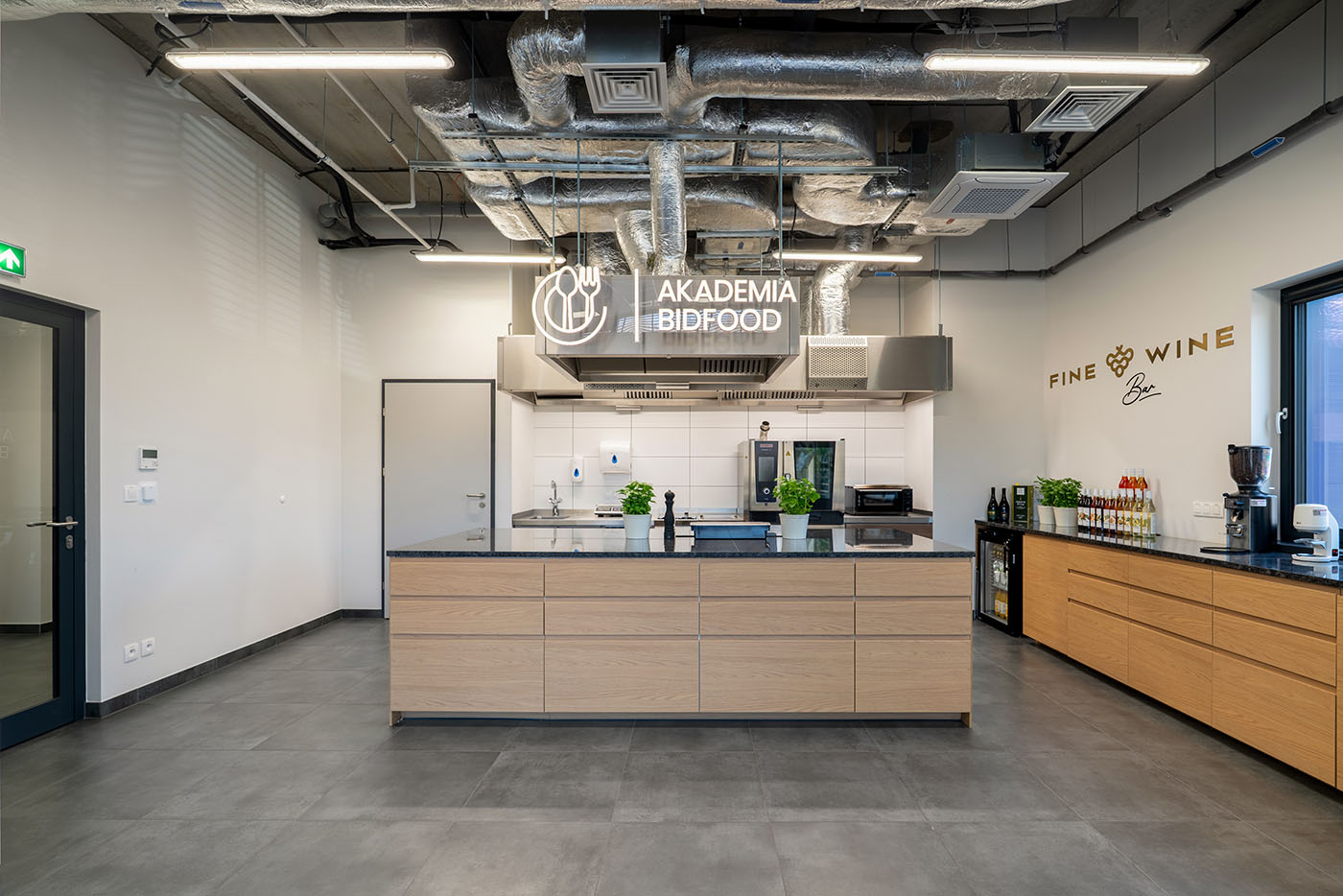 Recepcja z drewnianą ladą i podświetlanym znakiem, Akademia Bidfood