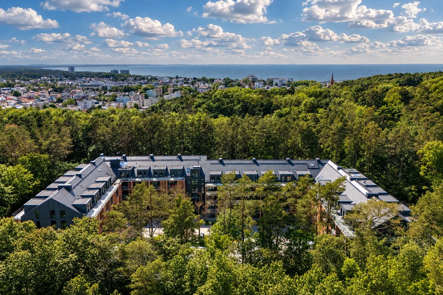 Resort Sea & Forest w Międzyzdrojach z drona, otoczony lasem, w tle miasto i morze
