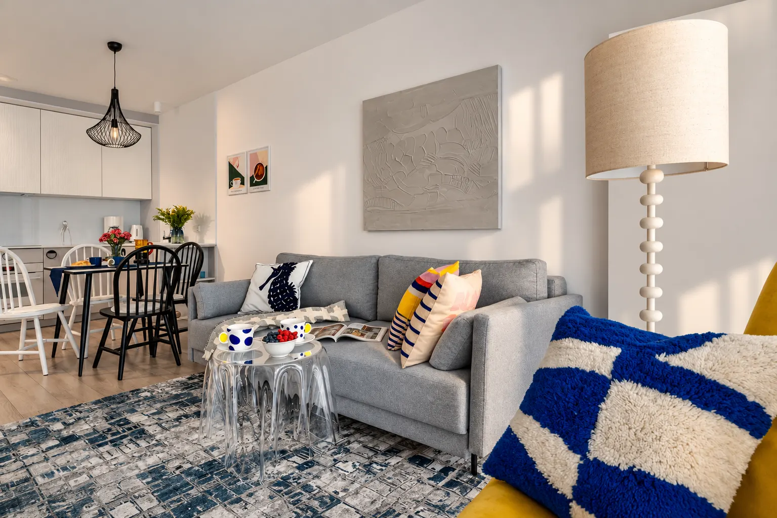 Salon z granatowo-białym dywanem i kolorowymi poduszkami, Apartament Mar, Kołobrzeg