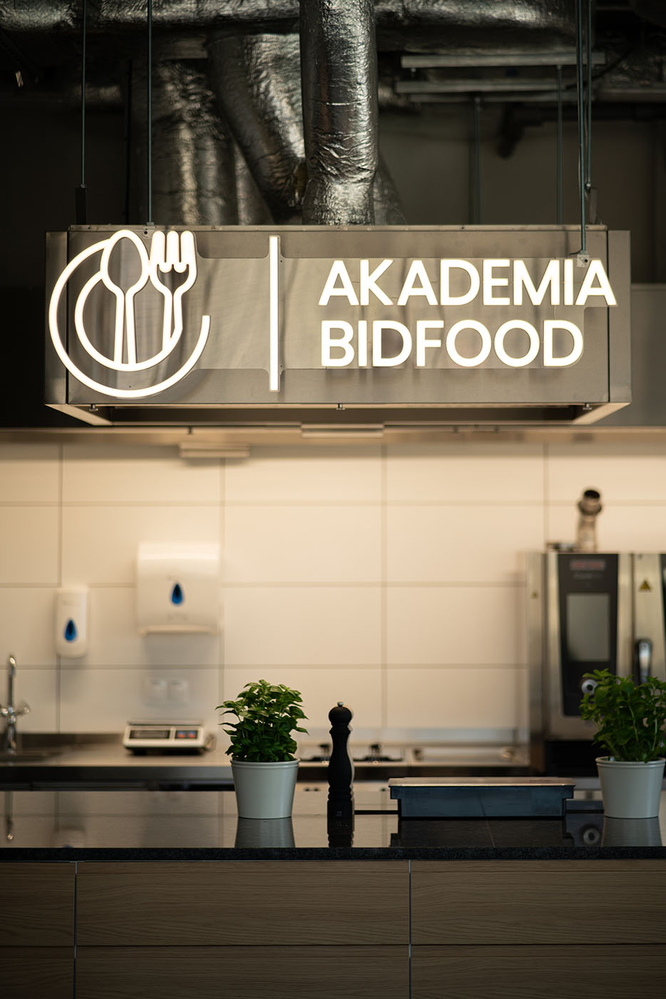Logotyp nad strefą kawową z roślinami, Akademia Bidfood