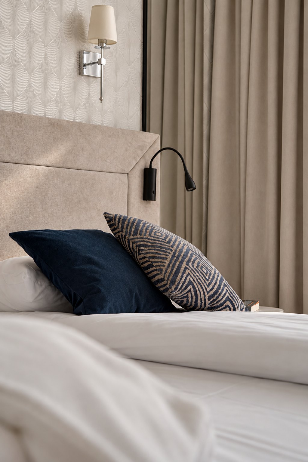 Detal łóżka i granatowych poduszek, Apartament w Central Park Mielno