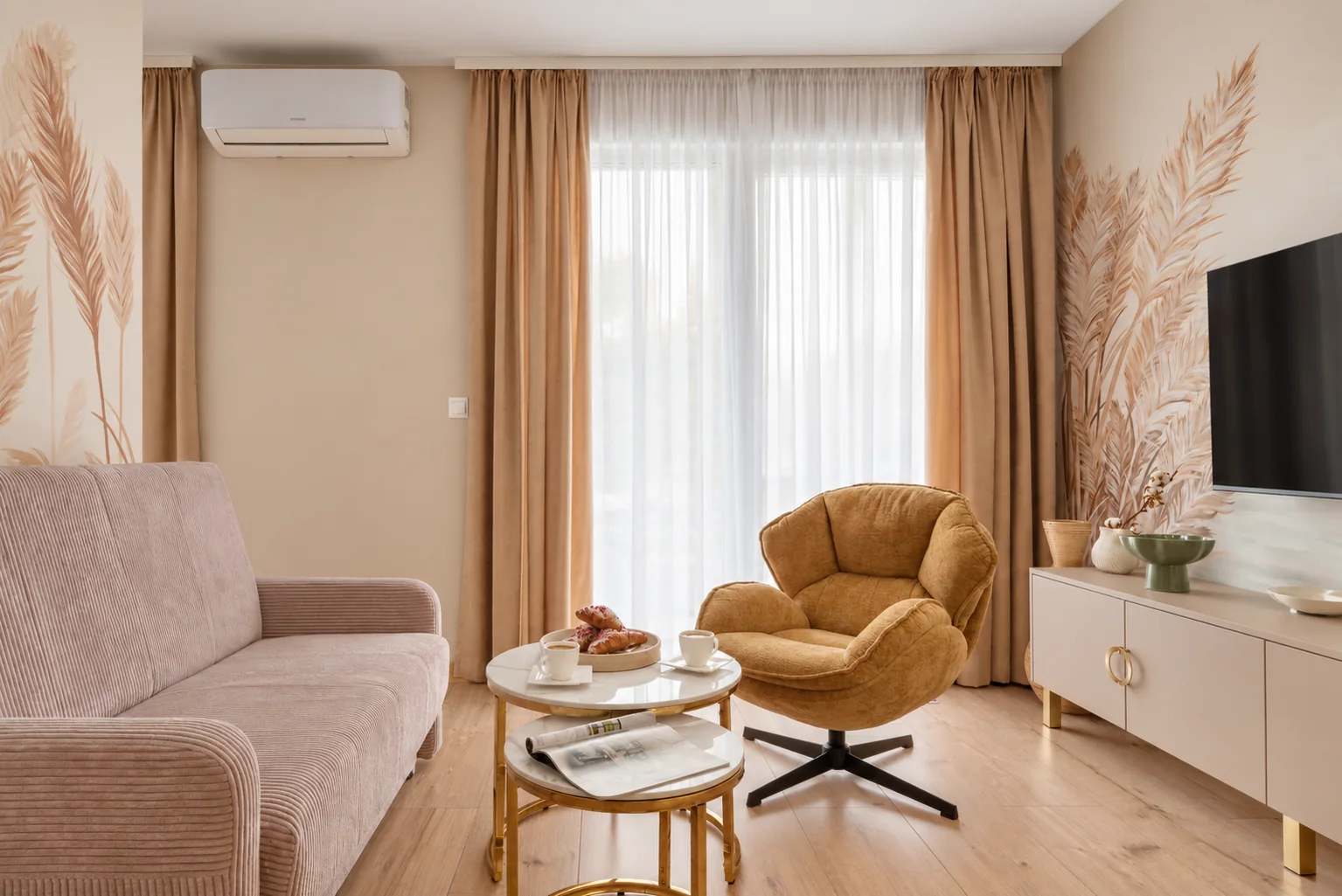 Strefa wypoczynku z oknem, fotelem i sofą w apartamencie Klifowa 22 w Rewalu