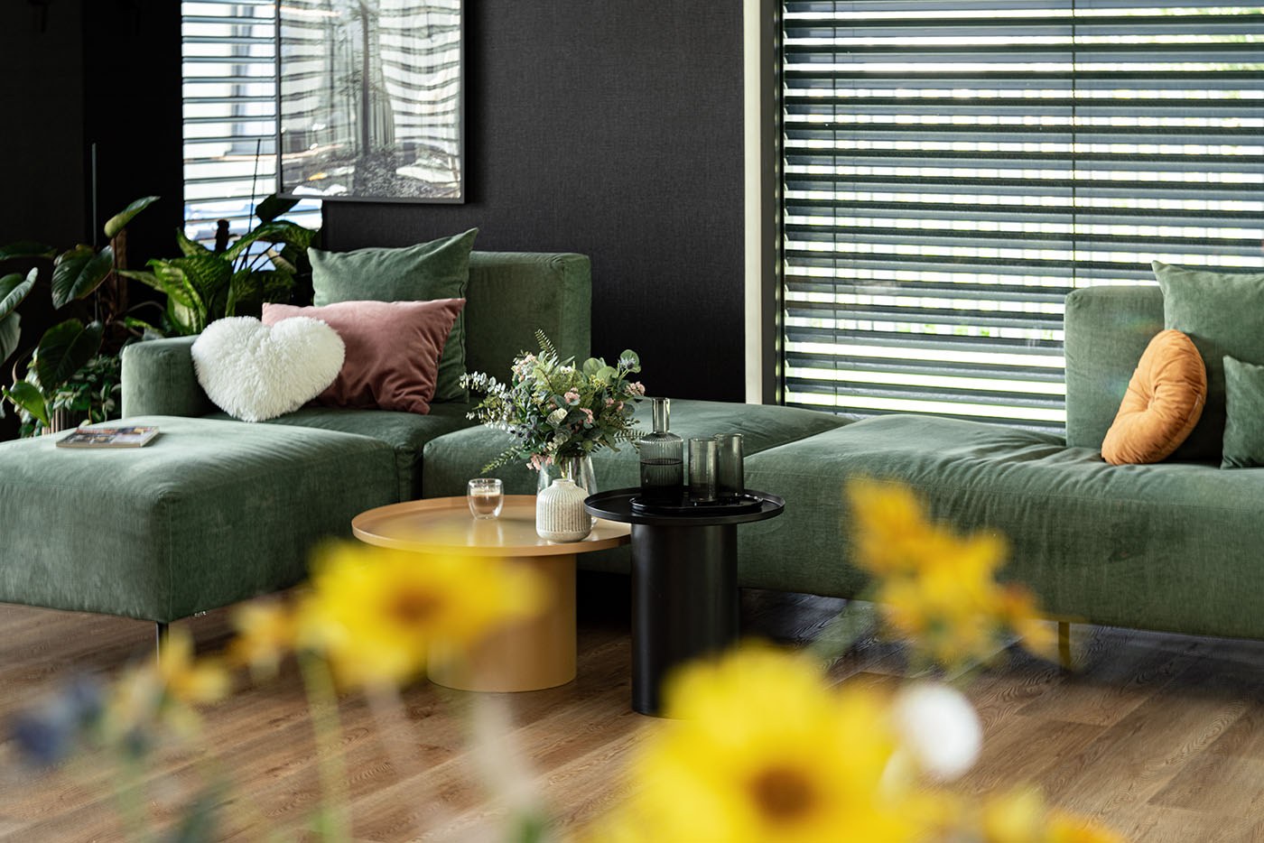 Salon domu jednorodzinnego w Szczecinie z zieloną sofą w naturalnym świetle