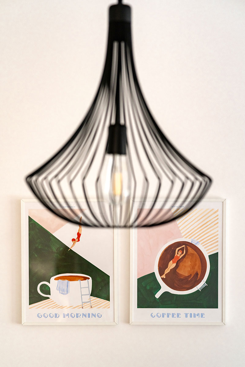 Czarna lampa wisząca nad grafikami, Apartament Mar, Kołobrzeg