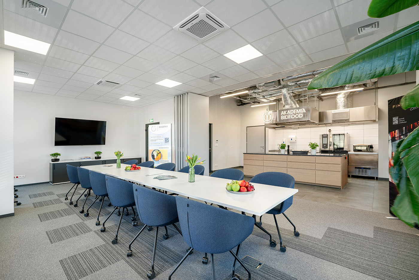 Sala szkoleniowa z niebieskimi krzesłami i ekranem, Akademia Bidfood